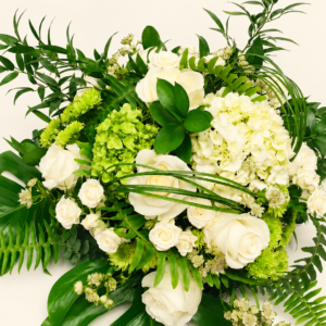 Bouquet blanc et vert avec roses, hortensias et feuillage sur fond ivoire
