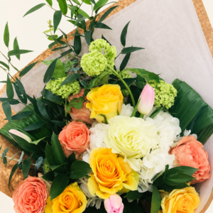 Bouquet de roses jaunes et pêche avec tulipes roses sur fond neutre