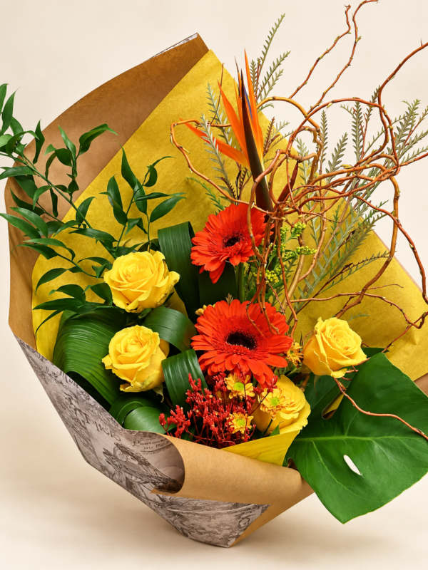 Bouquet Nathalie avec roses jaunes et gerberas orangés dans un emballage doré sur fond neutre