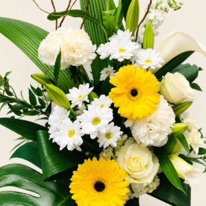 Corbeille de fleurs jaunes, blanches et vertes sur fond ivoire