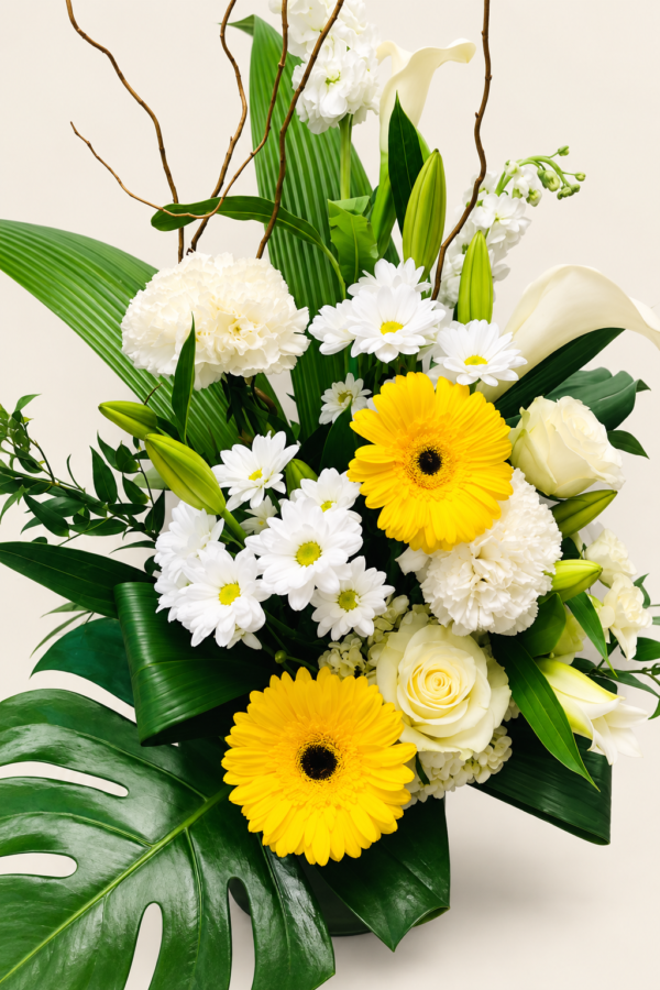 Corbeille de fleurs jaunes, blanches et vertes sur fond ivoire