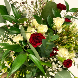 Bouquet sauvage de roses ivoire et bourgogne avec eucalyptus sur fond crème pâle