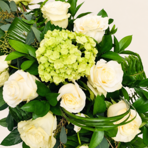 Coussin de cercueil avec roses blanches sur fond ivoire