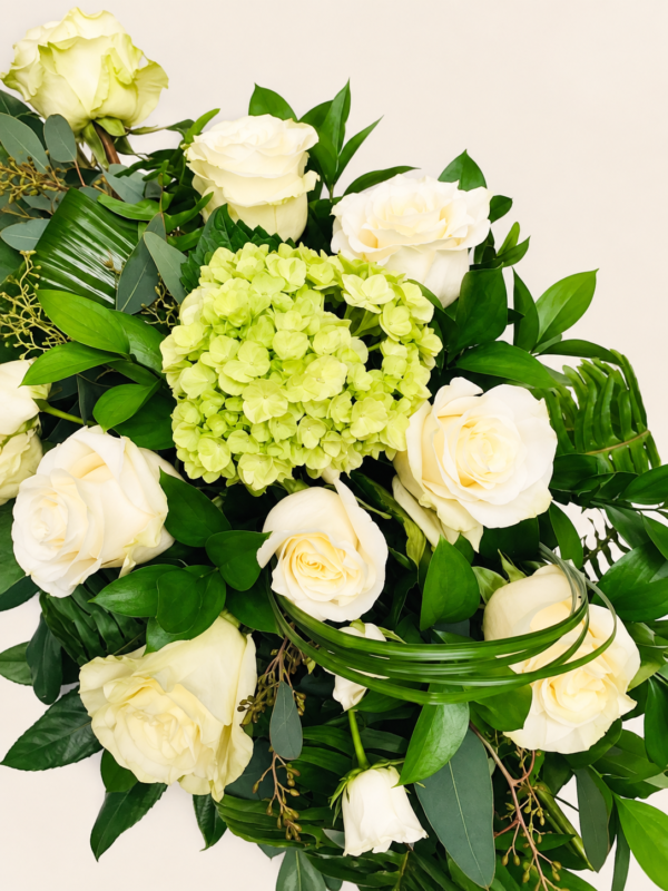 Coussin de cercueil avec roses blanches sur fond ivoire