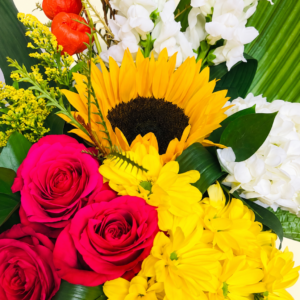Bouquet coloré avec tournesol, roses fuchsia et fleurs jaunes et blanches sur fond ivoire