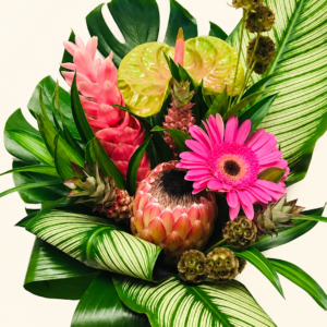 Bouquet de fleurs exotiques avec anthuriums, protéa et feuillage sur fond crème pâle