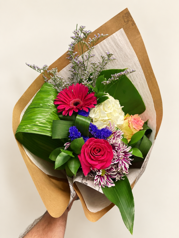 Bouquet Alexia fuchsia avec gerbera, rose et papier de soie sur fond crème pâle