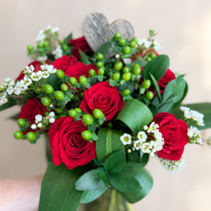 Bouquet pour l’amour aux roses rouges et cœur en bois sur fond crème pâle