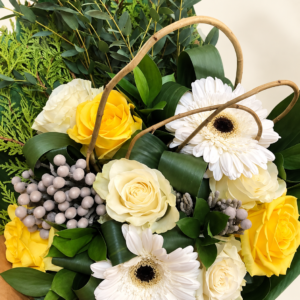 Bouquet de roses jaunes et ivoire, gerberas blancs et feuillage sur fond crème pâle