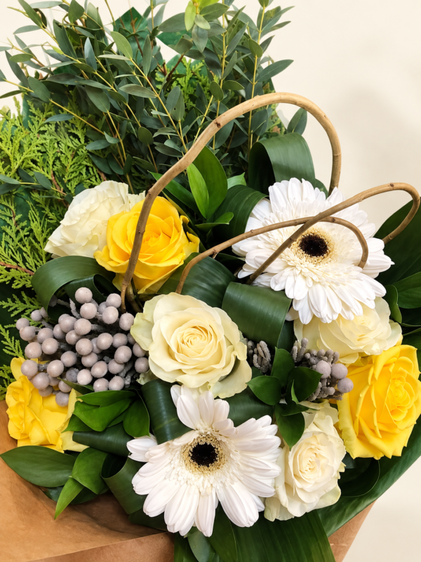 Bouquet de roses jaunes et ivoire, gerberas blancs et feuillage sur fond crème pâle