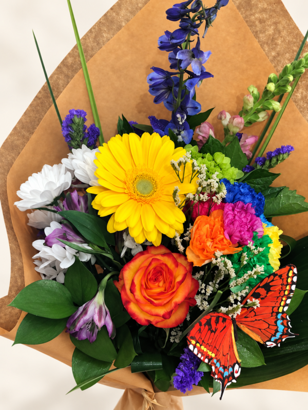 Bouquet de fleurs Le magnifique avec gerbera jaune, rose orangée et papillons décoratifs sur fond crème pâle