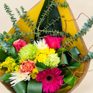 Bouquet Sabrina coloré dans son emballage jaune et kraft sur fond crème pâle