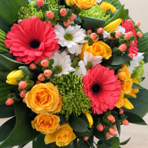 Bouquet Le merveilleux, gerberas roses, roses jaunes et fleurs blanches sur fond crème pâle