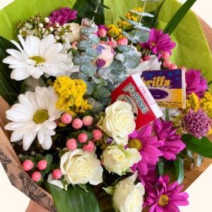 Bouquet fleurs et bonbons avec emballage vert conservé sur fond ivoire