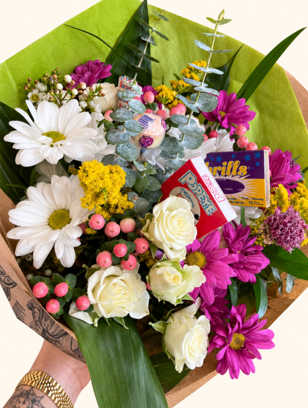 Bouquet fleurs et bonbons avec emballage vert conservé sur fond ivoire