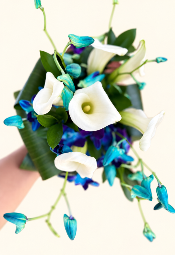 Bouquet de mariée calas et dendrobium bleu sur fond ivoire