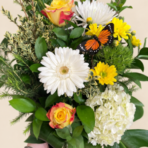 Bouquet Monarch avec papillon décoratif, roses jaunes, gerbera blanc et hortensia sur fond crème pâle