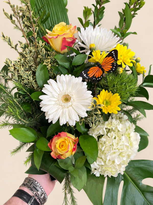 Bouquet Monarch avec papillon décoratif, roses jaunes, gerbera blanc et hortensia sur fond crème pâle