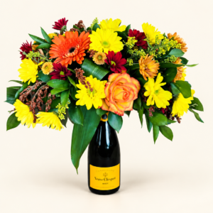 Arrangement de fleurs jaunes, orange et bourgogne sur une bouteille, sur fond ivoire