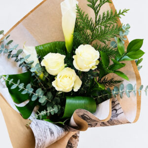 Bouquet de roses et callas blancs avec feuillage et papier kraft sur fond pâle