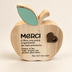 Décoration en bois en forme de pomme, message Merci, sur fond crème pâle